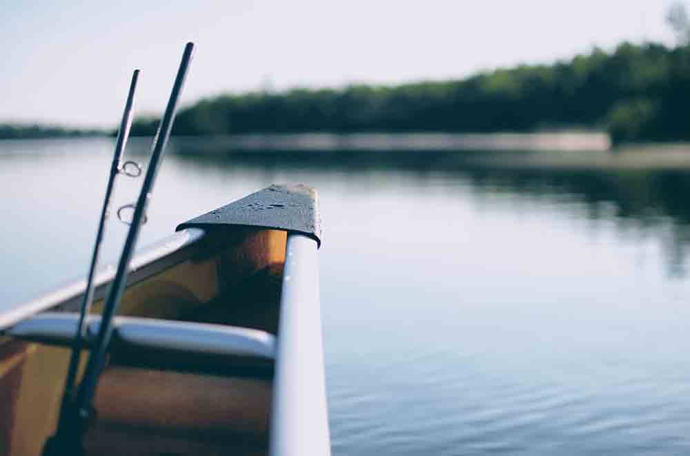 canoe on lake with fishing poles